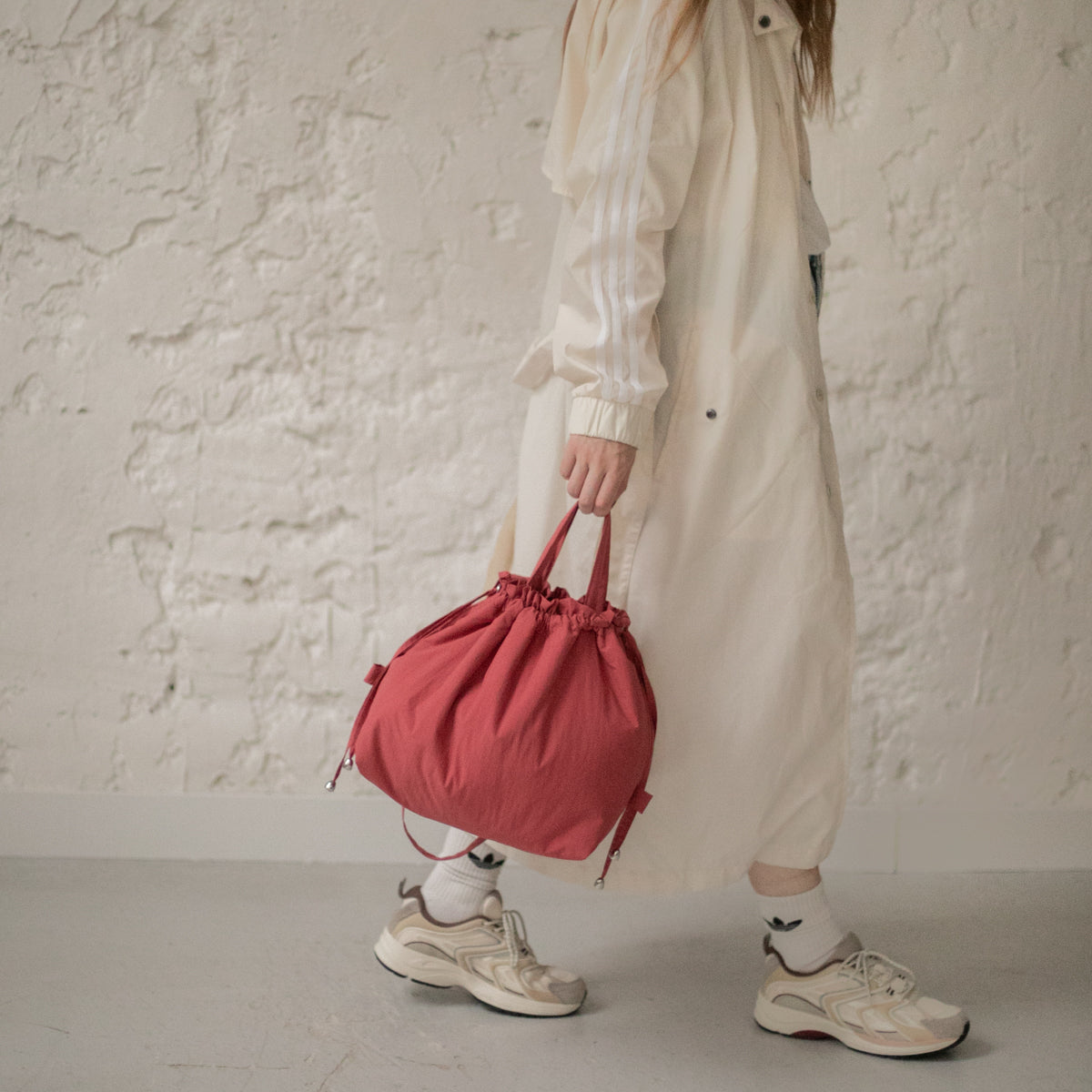Sac bourse Manhattan rouge corail taille M porté à la main – patron de couture Ikatee