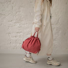 Sac bourse Manhattan rouge corail taille M porté à la main – patron de couture Ikatee